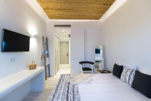 a bedroom with a bed and a tv on a wall at Thomais Studios in Naxos Chora