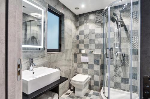 a bathroom with a sink and a toilet and a shower at The District Hotel in St Julian's