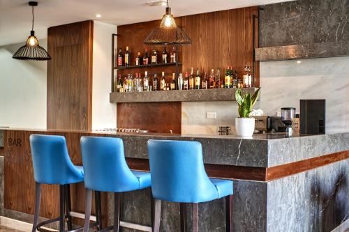 a bar with blue bar stools in a restaurant at The District Hotel in St Julian's