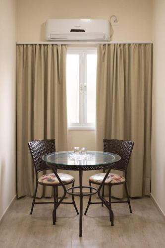 a dining room table with chairs and a window at Pousada Serra Nascente do Sol in Espirito Santo Do Pinhal