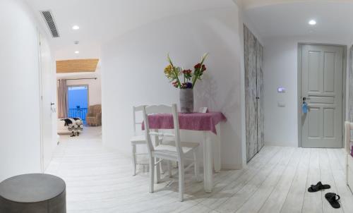 a white room with a table and chairs and a dog at Thomais Studios in Naxos Chora