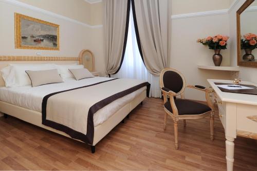 a hotel room with a bed and a desk and a desk at Grand Hotel Vittoria in Montecatini Terme