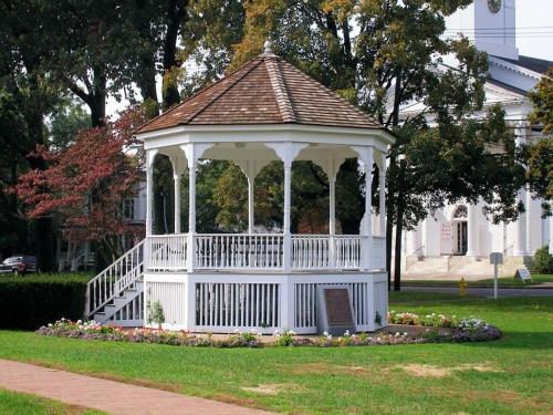 a white gazebo in the yard of a house at Norwalk Inn & Conference Center in Norwalk
