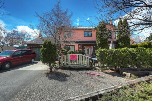 a red car parked in front of a house at Beds By the Bridge in Kelowna