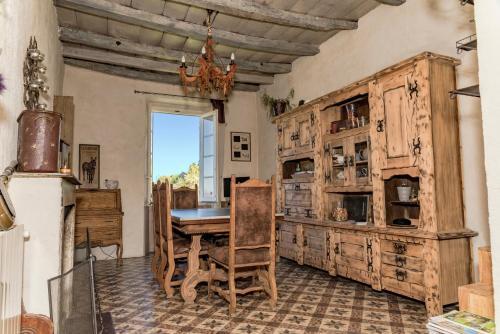 Chambre d'Hôtes La Marlotte في Castello-di-Rostino: غرفة طعام مع طاولة وخزانة خشبية