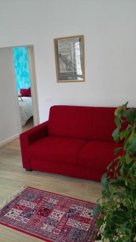 ローマにあるCASA CENEDA 46のリビングルーム(赤いソファ、ラグ付)