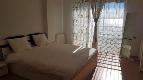 a bedroom with a bed and a large window at Voyage Residence in Mamaia