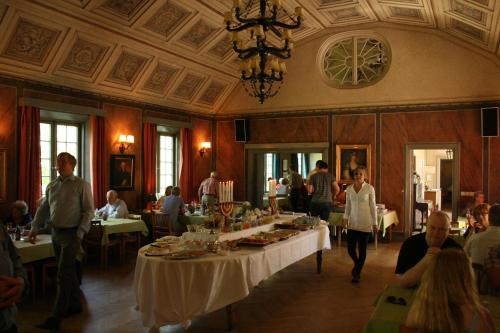 un grupo de personas sentadas en mesas en un restaurante en Forsbacka Wärdshus, en Forsbacka