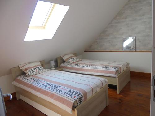 two beds in a attic room with a skylight at Les Cygnes in Criel-sur-Mer