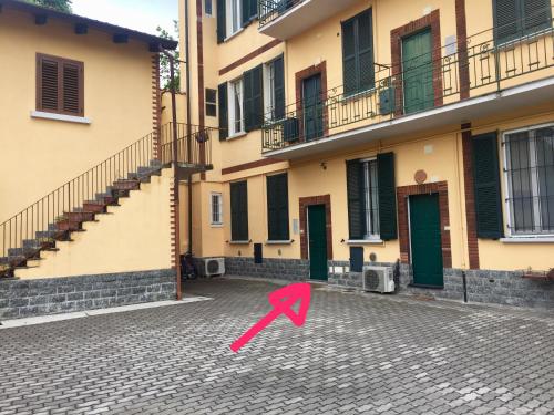 una flecha rosa en una calle frente a un edificio en BNBOOK - Green Zone Studio, en Paderno Dugnano