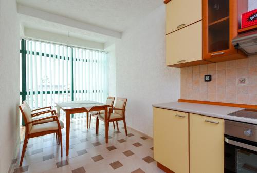 a kitchen with a table and chairs in a room at Hotel Green Center Gili in Gostivar