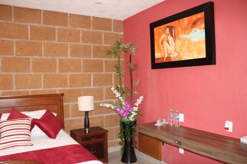 a bedroom with a bed and a brick wall at Hotel Boutique La Herencia in Tequisquiapan