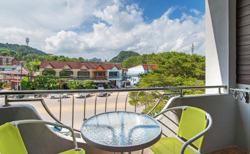 balcón con mesa, sillas y vistas a la ciudad en Mukanda Residence, en Ao Nang Beach