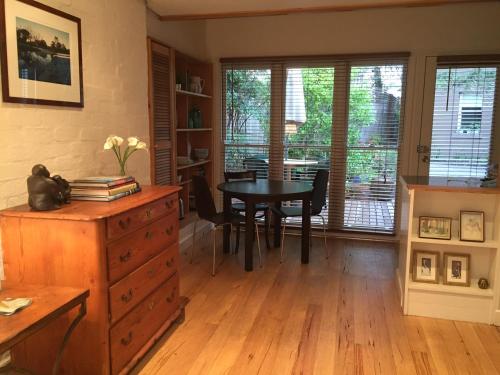 a dining room with a table and chairs and a table at Garden Cottage St Kilda in Melbourne