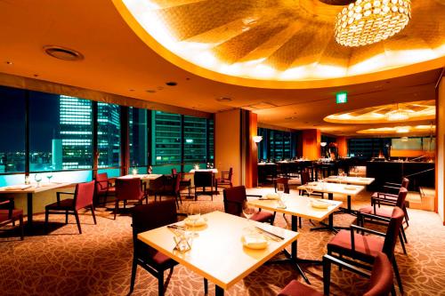 a restaurant with tables and chairs and a large ceiling at Meitetsu Grand Hotel in Nagoya