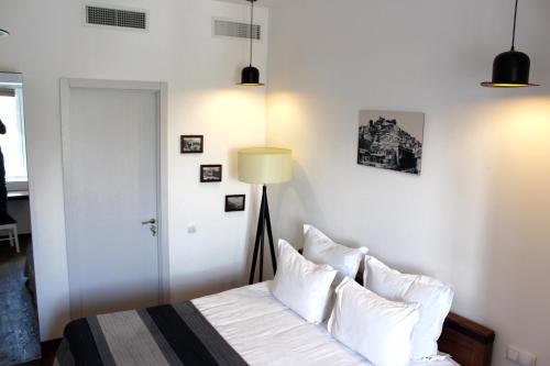 a bedroom with a bed with white sheets and pillows at Citadel Express in Tbilisi City