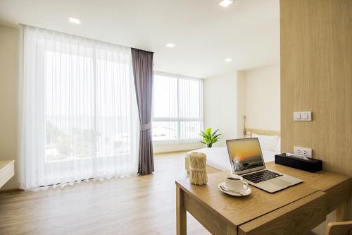 a room with a desk with a laptop on it at Karin hotel & Service apartment - SHA Extra Plus in Si Racha