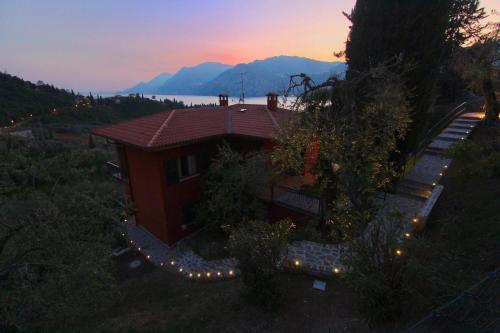 an aerial view of a house with a sunset in the background at red house conditioned whit pool enchanting lake view in Malcesine
