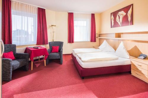 une chambre d'hôtel avec un lit, une table et des chaises dans l'établissement Gästehaus Bakker, à Norderney