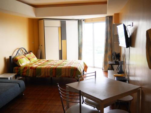 a room with a bed and a table and a couch at Jomtien beach Condominium S2 in Jomtien Beach