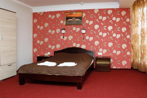a bedroom with a bed and a red wall at City Club European in Chernivtsi