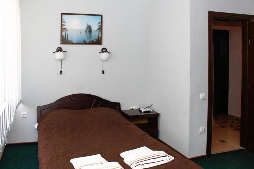 a bedroom with a bed and a picture on the wall at City Club European in Chernivtsi