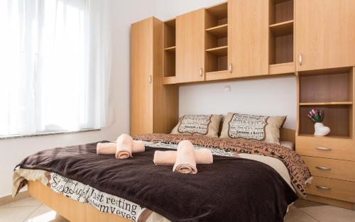 a bedroom with a bed with towels on it at Apartments Kraljić in Baška