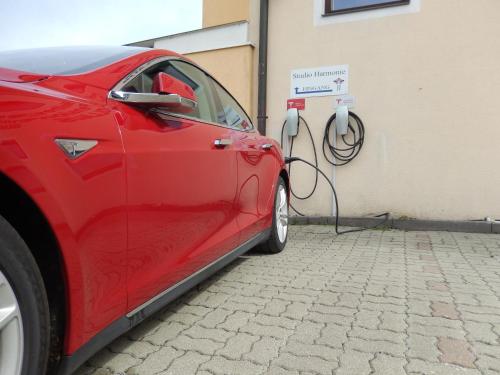 a red car is hooked up to a charging station at Wellness Pension Hollaus in Kirchberg in Tirol