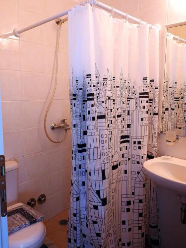 a bathroom with a shower curtain with a toilet and a sink at Chora View in Kýthira