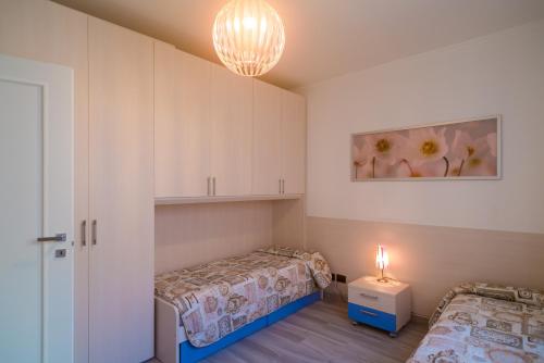 een kleine kamer met 2 bedden en een lamp bij Appartamento Molo B in Portoferraio