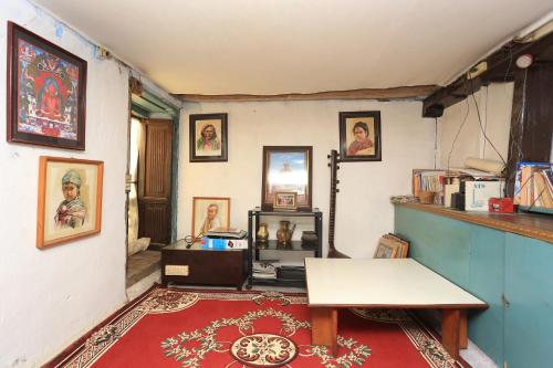 a room with a table and some pictures on the wall at Patan Community Stay in Pātan