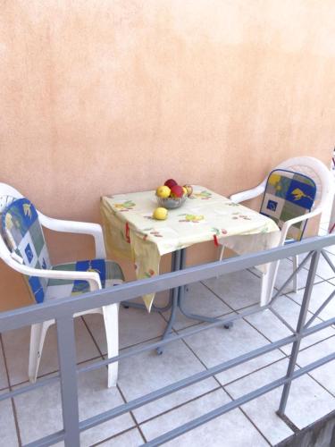 a table with chairs and a table with fruit on it at Apartments Jerković in Stari Grad