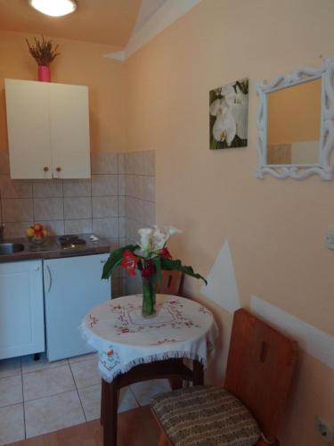 a kitchen with a table with a vase of flowers on it at Apartments Jerković in Stari Grad