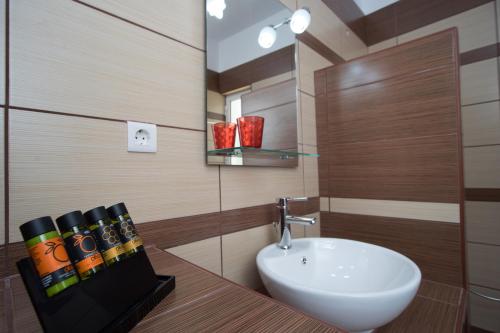 a bathroom with a white sink and a mirror at Naiades Luxury Apartments in Kalathas