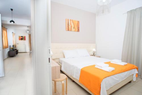 1 dormitorio blanco con 1 cama y 1 silla en Naiades Luxury Apartments, en Kalathas