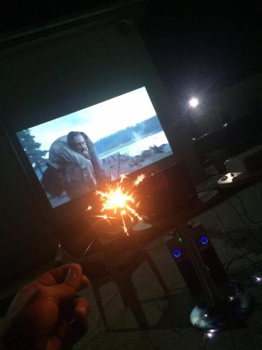a person holding a sparkler in front of a television at Paradise Investment Resort in Tʼelavi