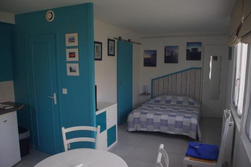 ディエップにあるStudio rez-de-jardinの小さなベッドルーム(ベッド1台、青いドア付)