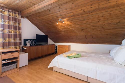 a bedroom with a white bed and a wooden ceiling at Holiday Home Jana in Orebić