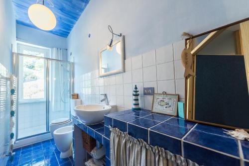y baño con lavabo, aseo y espejo. en Golfo dell'Isola Appartamento, en Spotorno