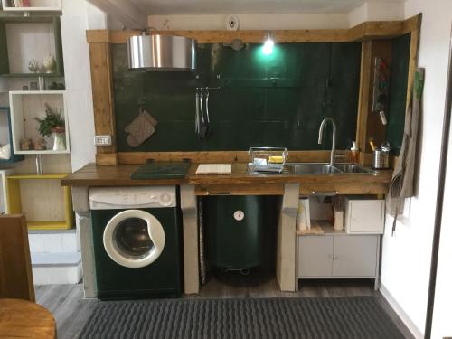 a small kitchen with a washing machine and a sink at Beeloft in Catania