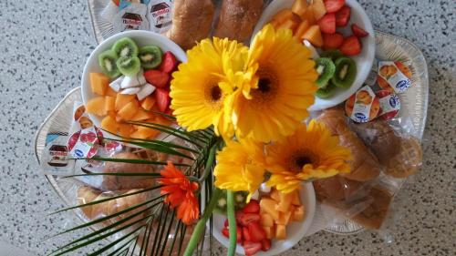 two plates of food with flowers on a table at Villa Laura Apartment in Giardini Naxos