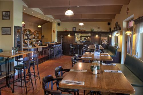 un restaurante con mesas y sillas de madera y un bar en Penzion U Broucka, en Milevsko