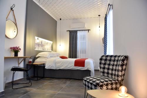 a bedroom with a bed and a table and chairs at Piteoussa in Hydra
