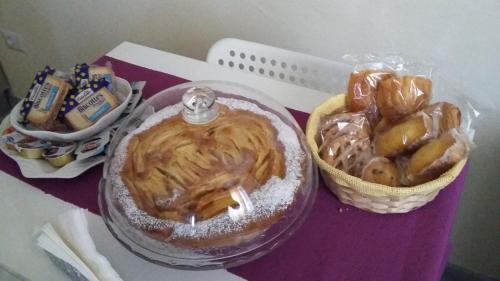 a table with a plate of food and a basket of pastries at B&B Gli Alberetti in Loreto