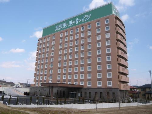 un grand bâtiment avec un panneau en haut dans l'établissement Hotel Route-inn Koriyama Inter, à Koriyama