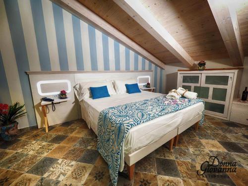 a bedroom with a bed with blue and white stripes at Residenza Donna Giovanna in Tropea