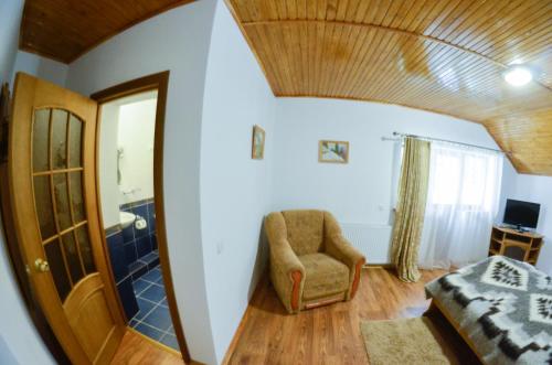 a bedroom with a bed and a chair and a mirror at Hovanka in Yaremche