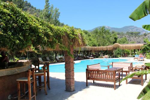 un complexe avec une piscine, une table et des chaises dans l'établissement Hotel Riverside, à Dalyan