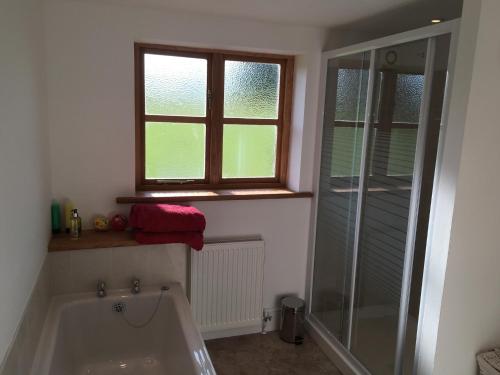 a bathroom with a bath tub and a window at Maesbury Riverside in Oswestry