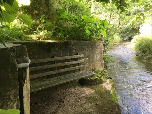 a wooden bench sitting next to a river at Maesbury Riverside in Oswestry